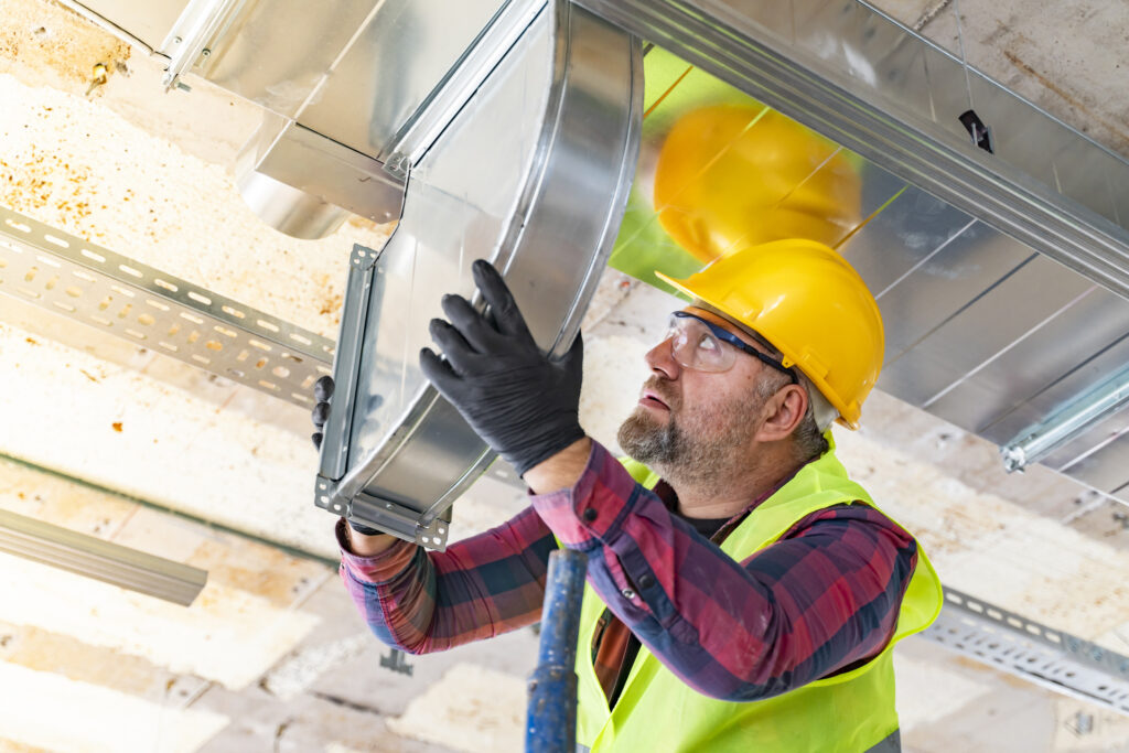 HVAC technician installing ventilation in new construction